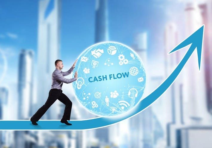 Mies työntää ylämäkeen sinistä palloa, jossa lukee Cash Flow.