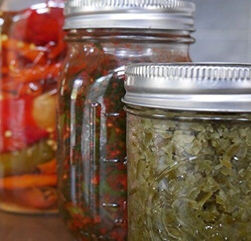 Kolme lasipurkkia, joissa on värikkäitä fermentoituja kasviksia