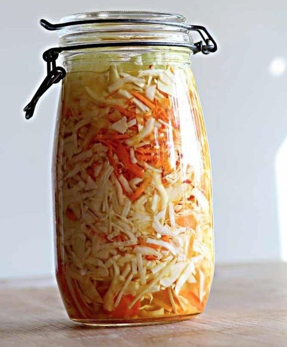 Lasipurkkiin säilöttyä fermentoitua kaalia ja porkkanaa